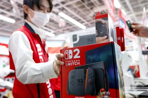 empleado vendiendo Nintendo Switch 2 en tienda japonesa durante lanzamiento consola